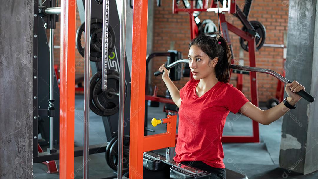 bela mulher apto muscular exercitando a construção de músculos e fitness mulher fazendo exercícios no ginásio. Aptidão - conceito de estilo de vida saudável