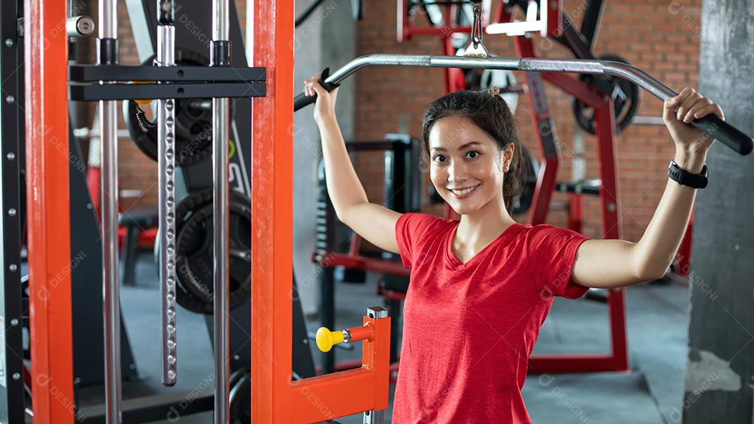 bela mulher apto muscular exercitando a construção de músculos e fitness mulher fazendo exercícios no ginásio. Aptidão - conceito de estilo de vida saudável
