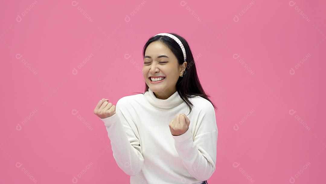 Mulher asiática sorrindo e dando os polegares para cima com alegria e emoção.