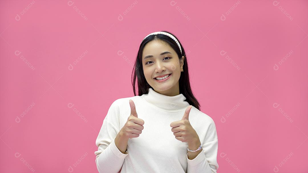 Mulher asiática sorrindo e dando os polegares para cima com alegria e emoção.