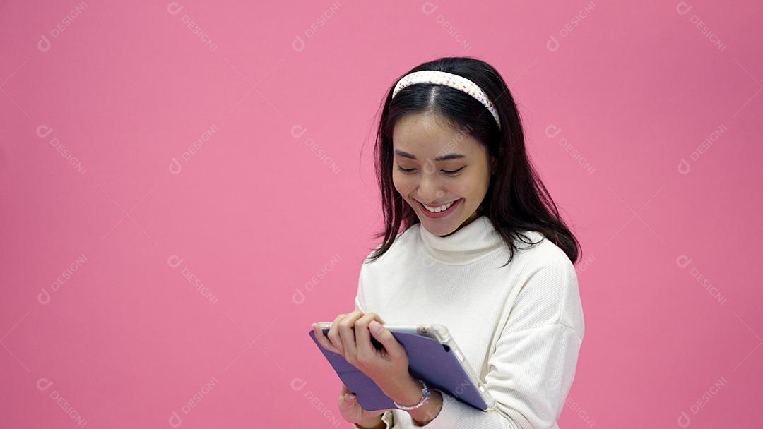 feliz jovem asiática sorrindo e se divertindo, rindo, olhando para o lado no fundo rosa