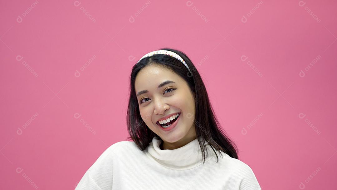 happy asian young woman smiling and having fun, laughing, looking to side on pink background