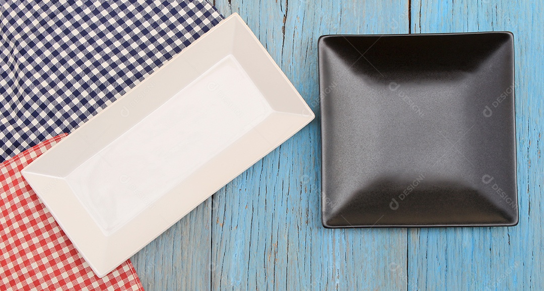 Prato preto e branco na toalha de mesa no fundo da mesa de madeira