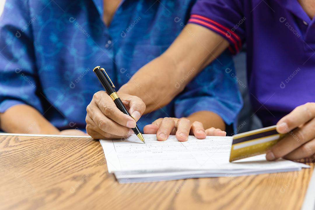 Idosos asiáticos segurando contrato de caneta pagamento cartão de crédito seguro papelada de cuidados de saúde ou relatório de documento conceito de finanças de compras.