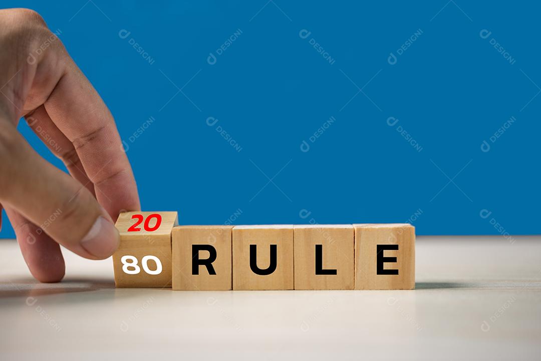 Mão segurando a regra de texto de cubo de madeira 80/20. Conceito econômico de finanças empresariais.