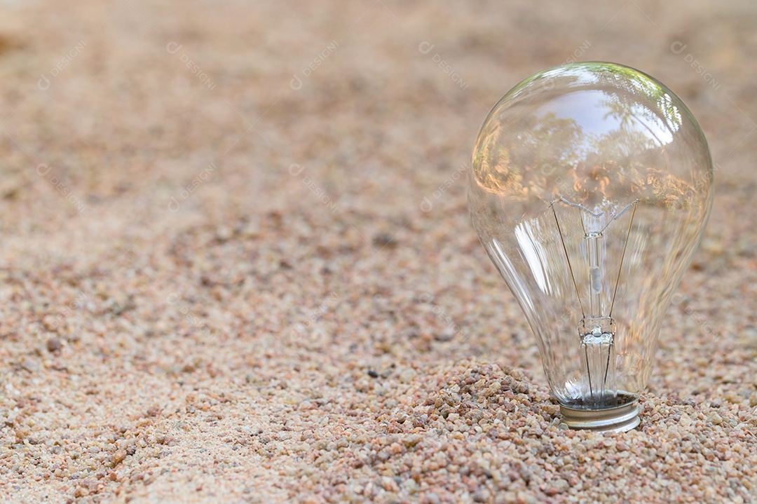 A lâmpada está vazia na areia. conceito de energia