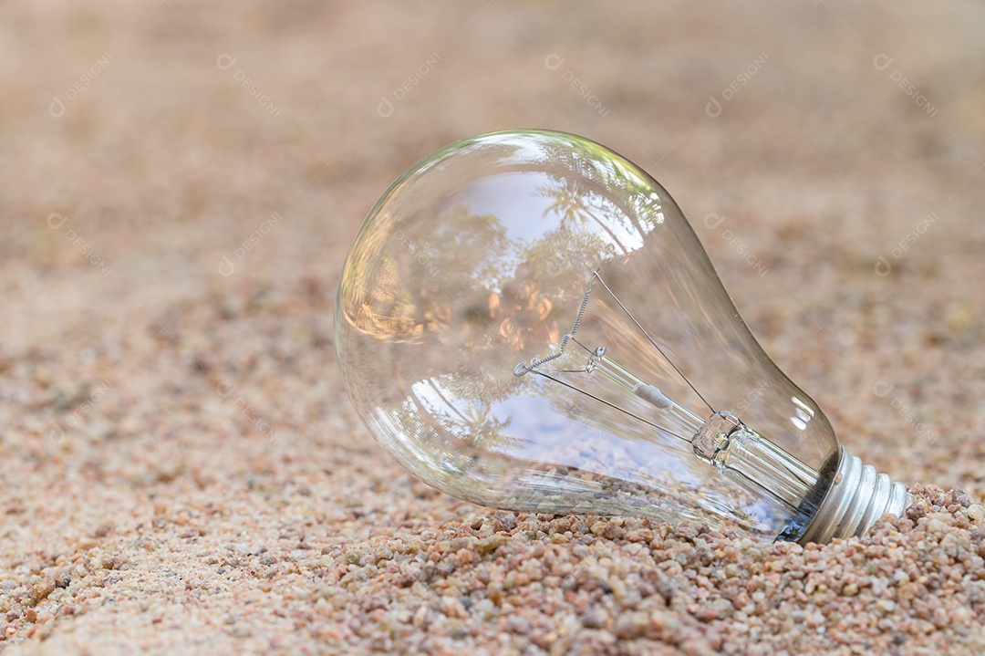 A lâmpada está vazia na areia. conceito de energia