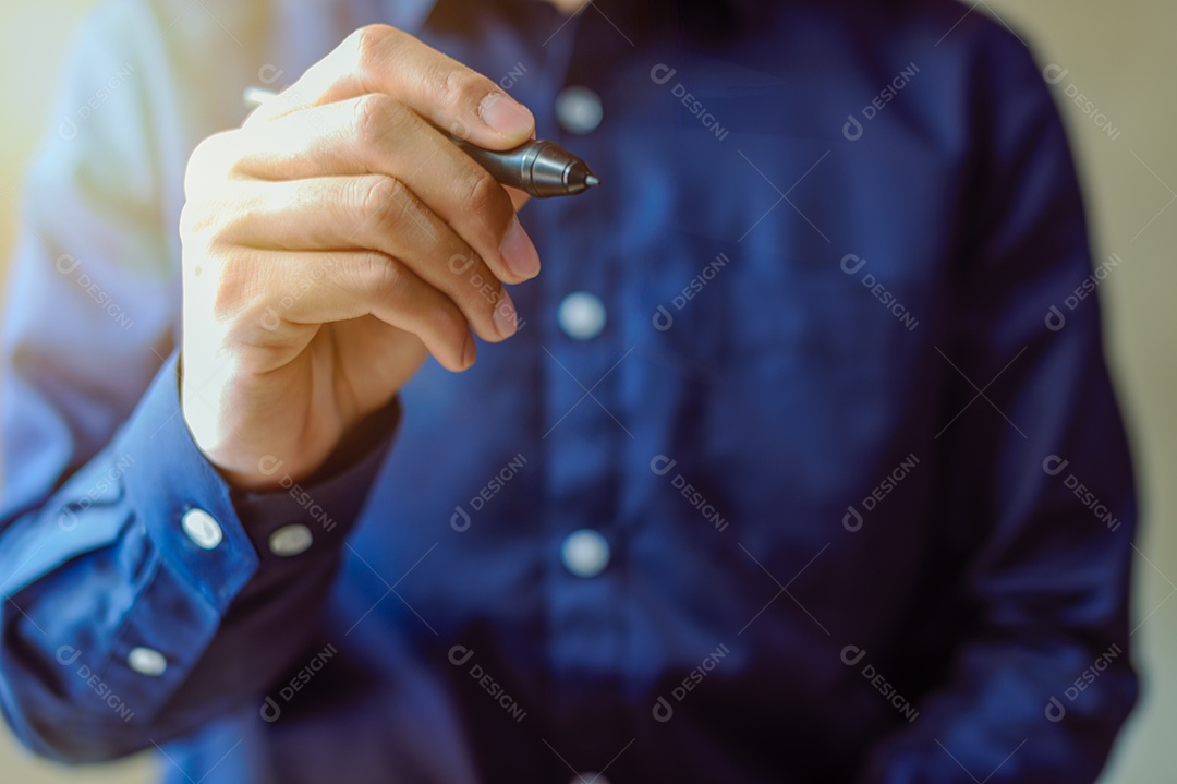 A business man in a blue shirt using a pen