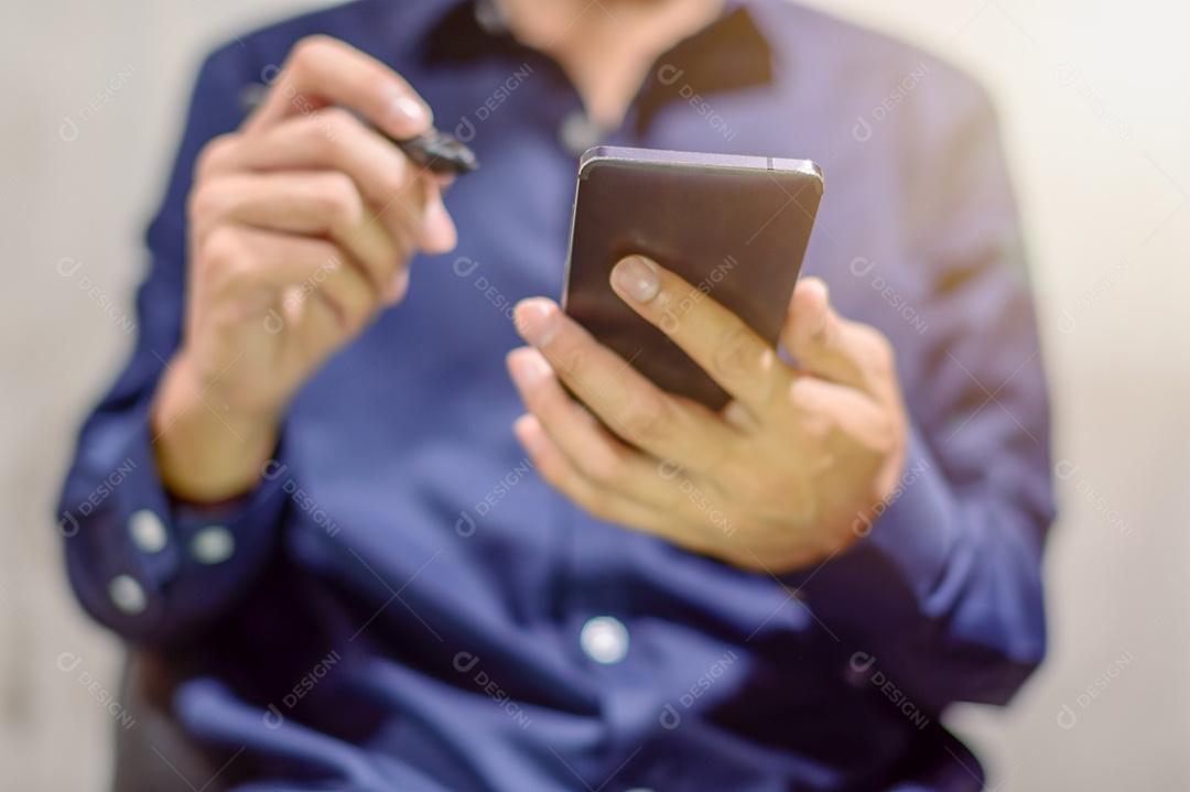 Pessoa de negócios usam um smartphone com uma caneta para fazer anotações