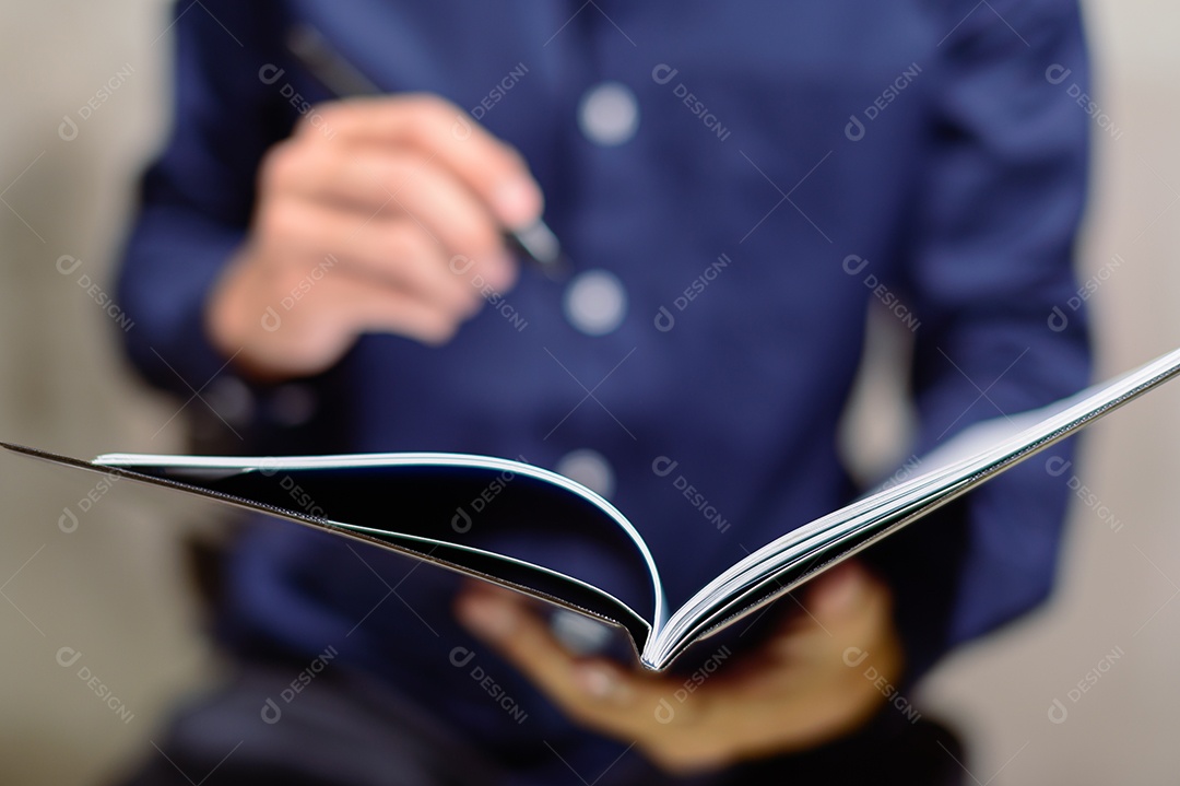 Um empresário em uma camisa azul Visualizando o relatório no notebook