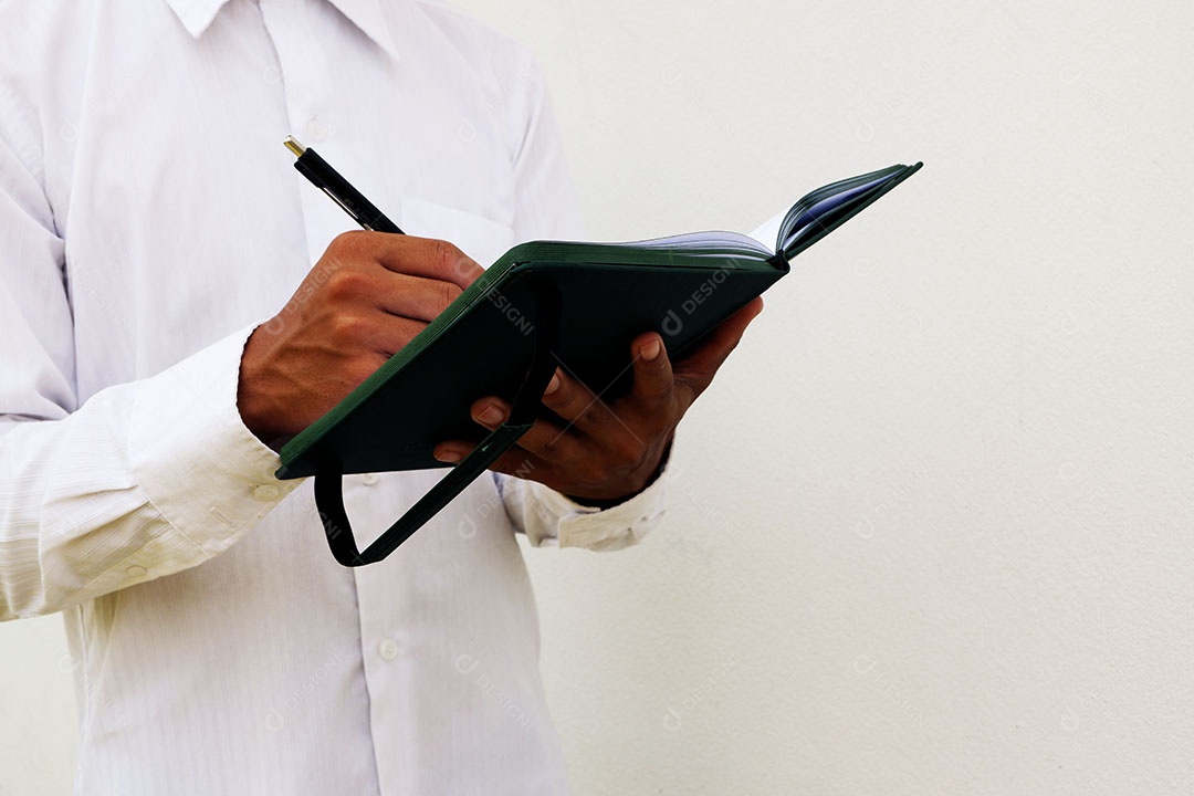 Empresário está escrevendo notas no caderno enquanto trabalha e explora algo isolado no fundo branco