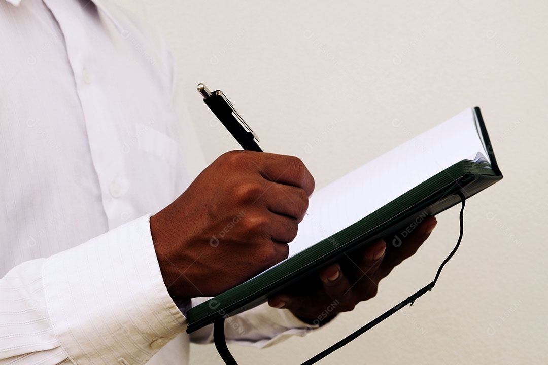 Empresário está escrevendo notas no caderno enquanto trabalha e explora algo