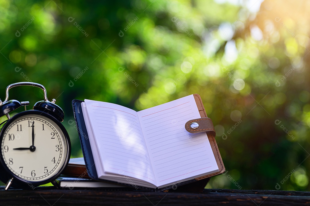 Caderno colocado sobre um fundo de madeira com bokeh