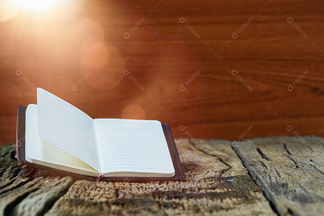 Os livro estão empilhados na mesa de madeira