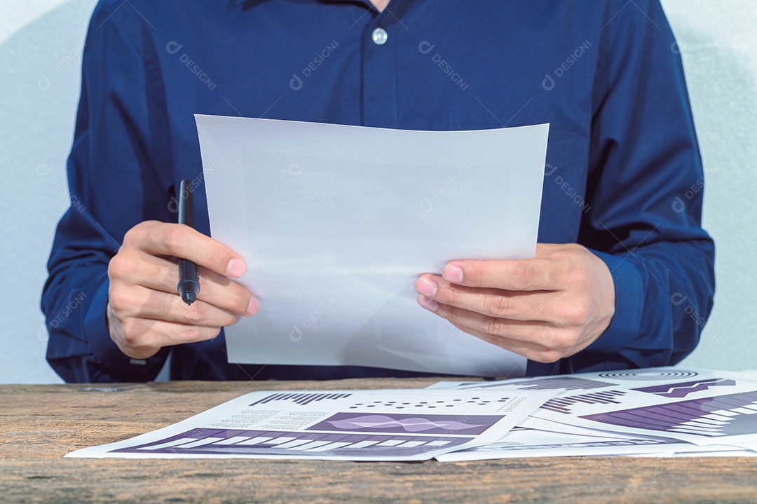 O homem de negócios verifica as contas e documentos sobre a mesa