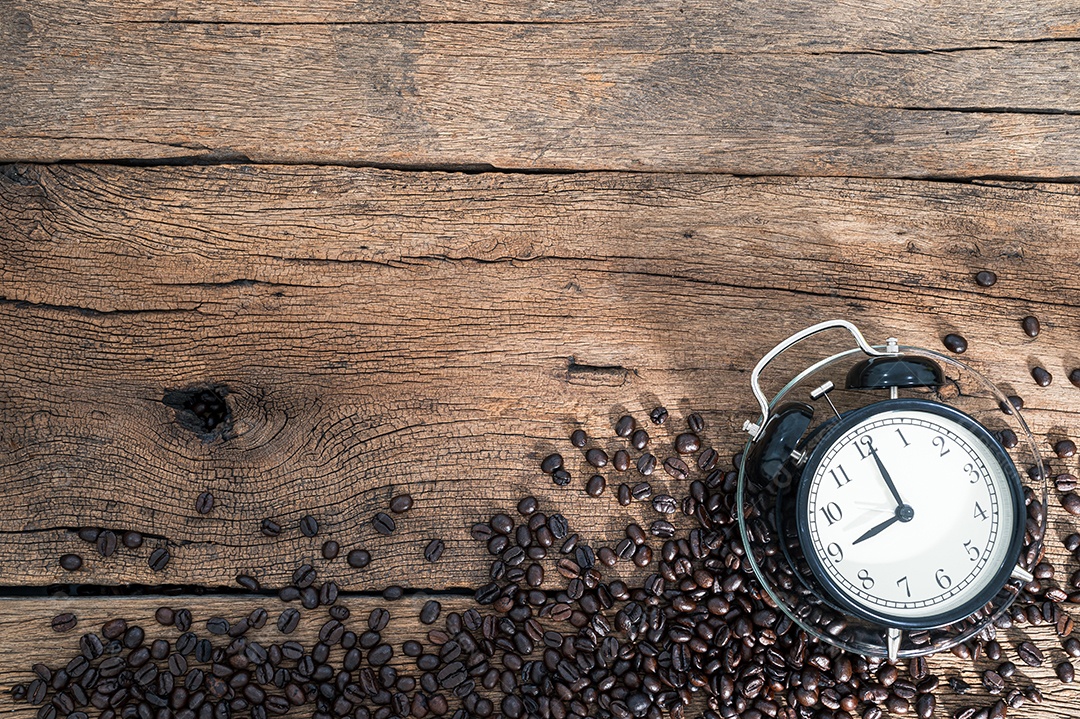 Relógio e grãos de café Sentado na vista superior da mesa