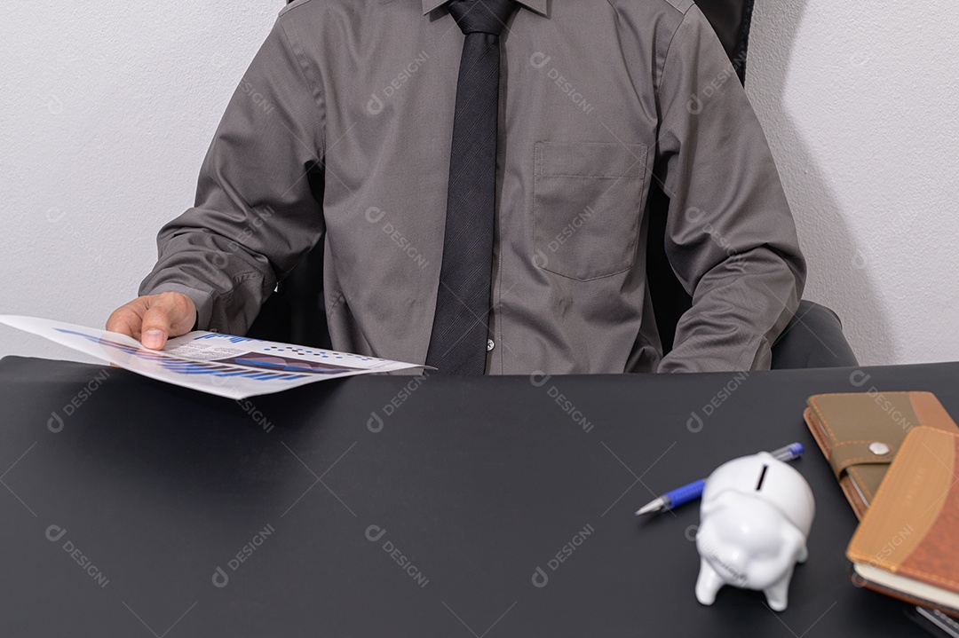 Empresário seguram cofrinhos em suas mesas