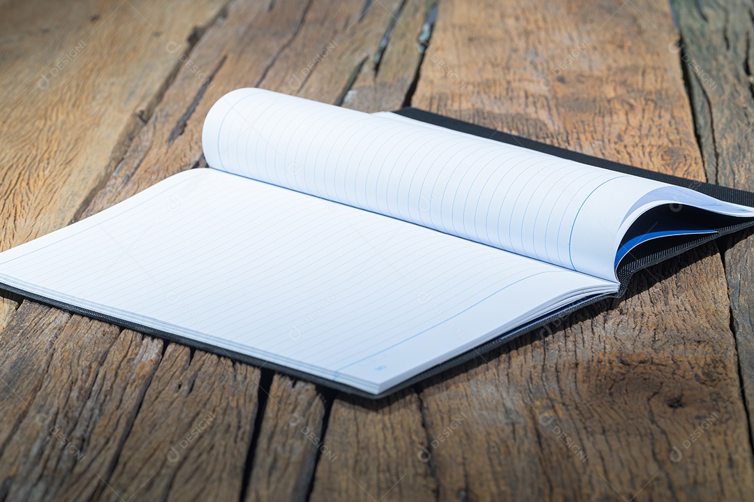 Um caderno em branco na mesa de madeira