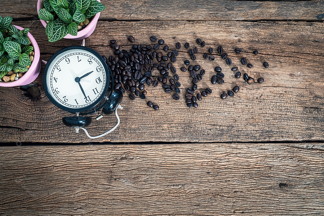 A clock and coffee beans on the table top view
