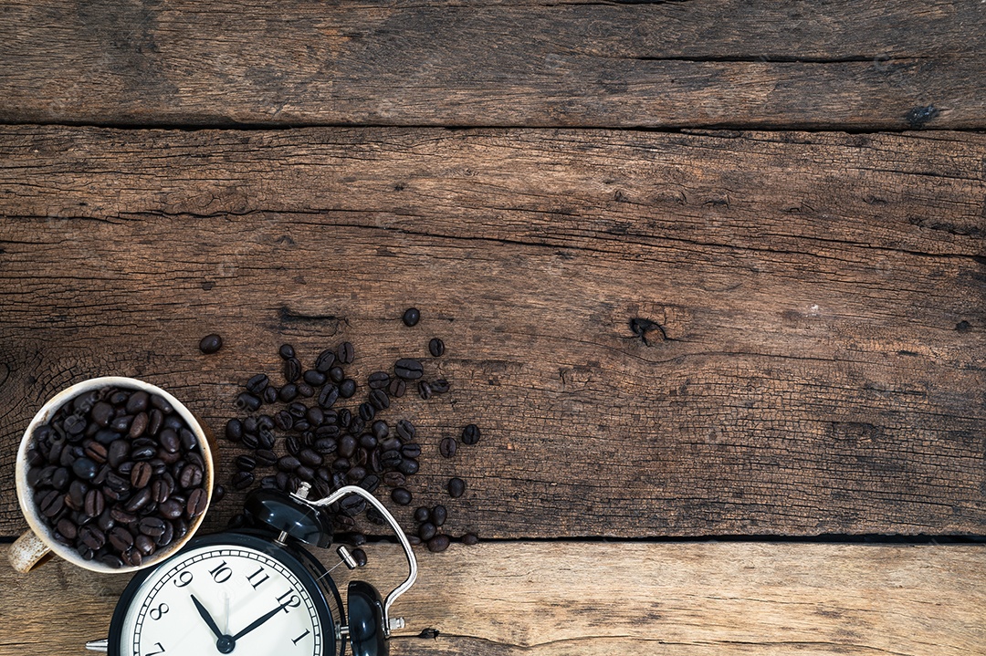 Xícara de grãos de café e um relógio Sentado na vista superior da mesa