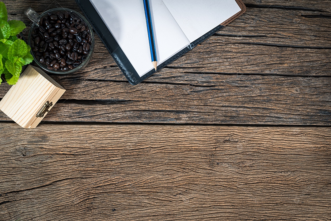 Um bloco de notas de grãos de café colocado sobre uma mesa de madeira