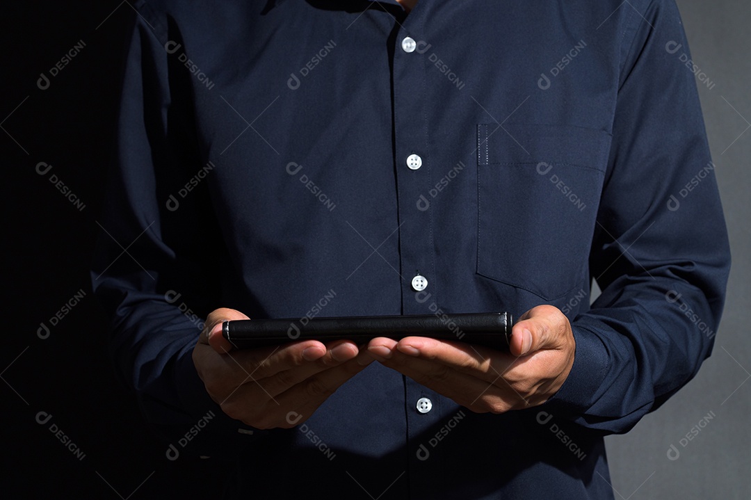 Um homem de negócios segurando um livro preto