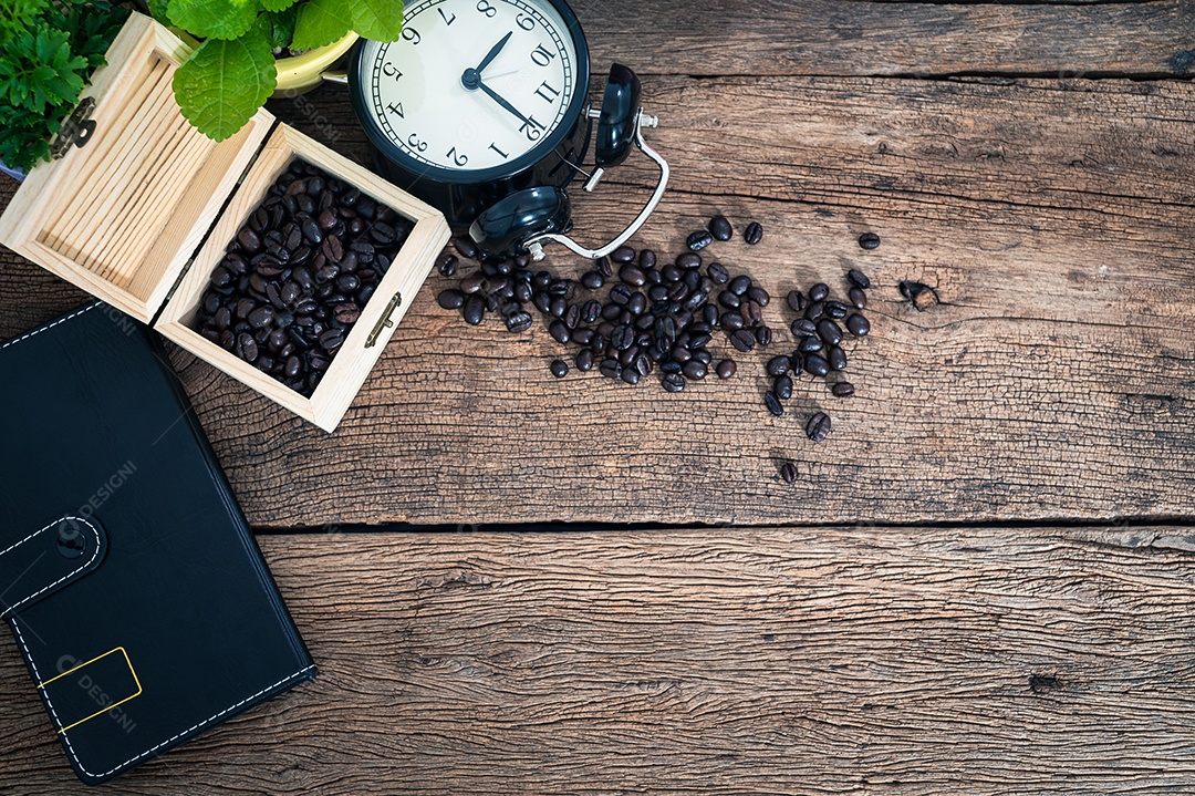 Caixa de grãos de café, livro, relógio na mesa, vista superior