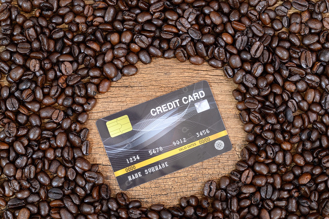 Cartões de crédito e grãos de café na vista superior da mesa