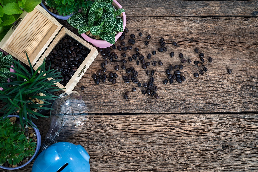 Lâmpada de cofrinho e grãos de café na vista superior da mesa