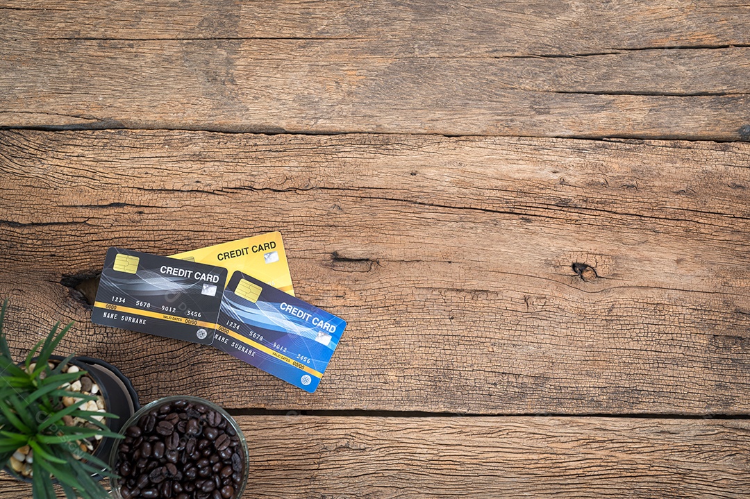 Cartão de crédito, uma árvore de grãos de café, colocada sobre uma mesa de madeira, vista superior