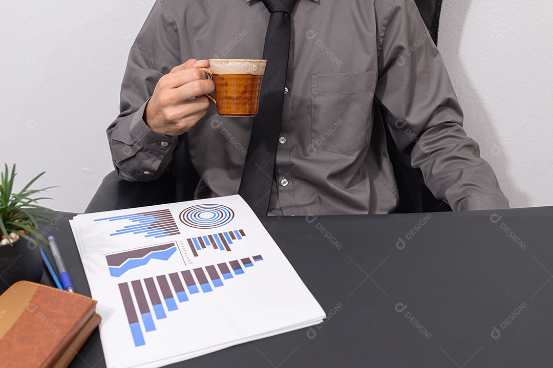 Empresário bebem café e olham para gráficos de renda