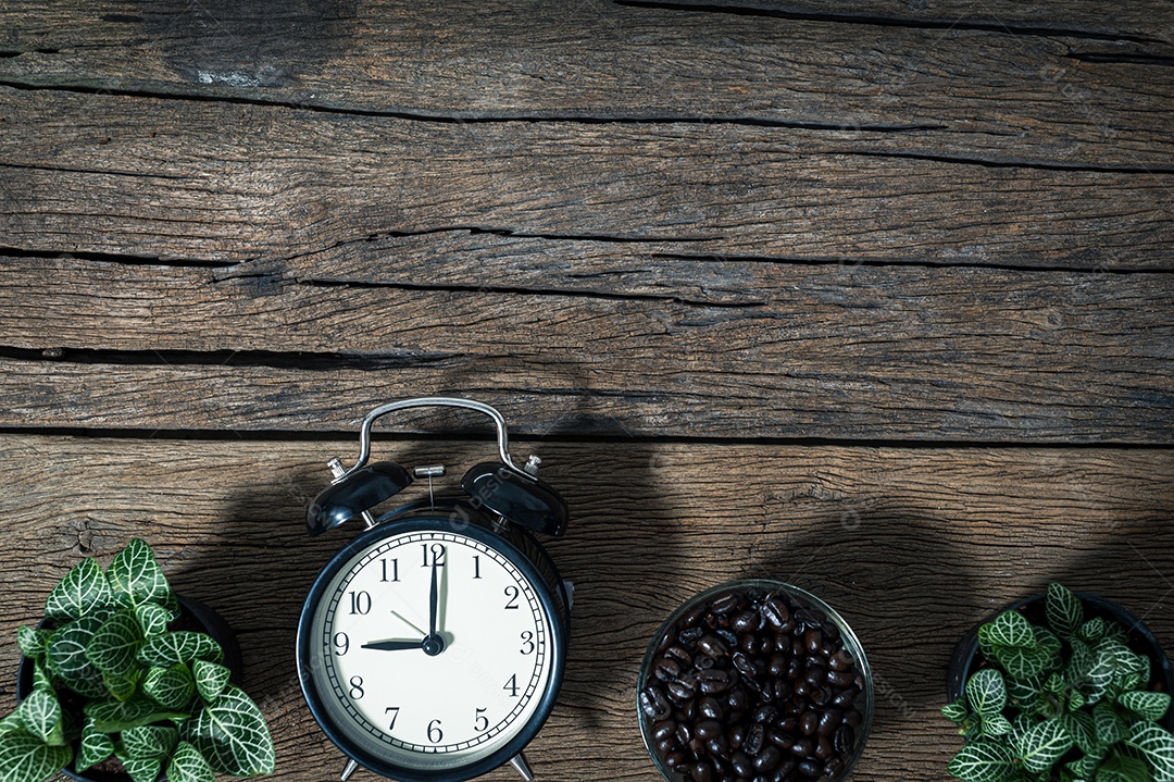 Relógio e uma caneca de grãos de café colocados na vista superior da mesa