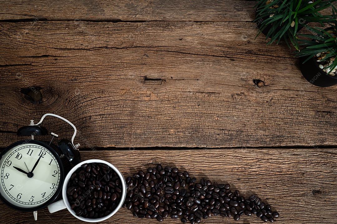 Um relógio e grãos de café na vista superior da mesa