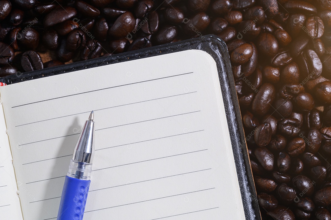 Caderno e caneta nos grãos de café