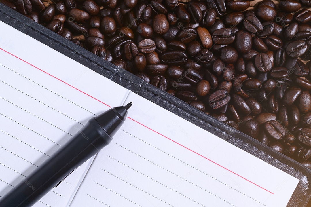 Caderno e caneta nos grãos de café