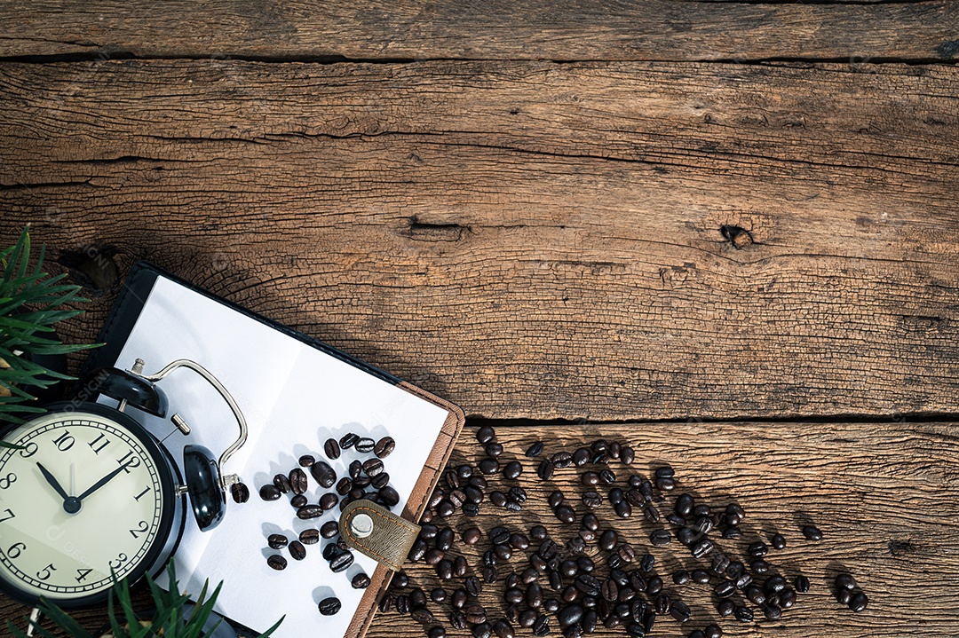 Um bloco de notas de grãos de café colocado sobre uma mesa de madeira