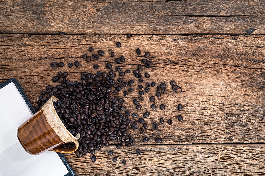 Xícara de grãos de café na vista superior da mesa