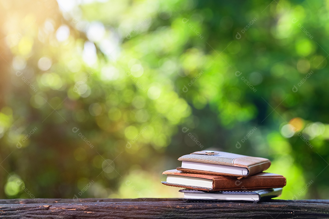 Caderno colocado sobre um fundo de madeira com bokeh
