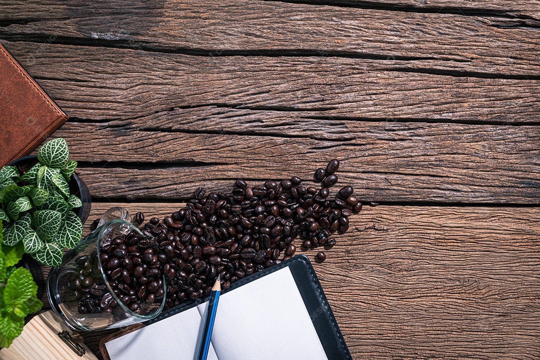 Um bloco de notas de grãos de café colocado sobre uma mesa de madeira