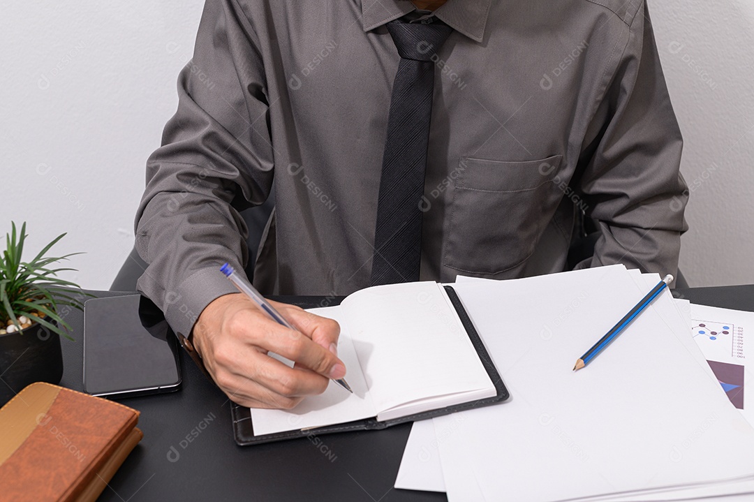 Empresário sentado em uma mesa tomando notas
