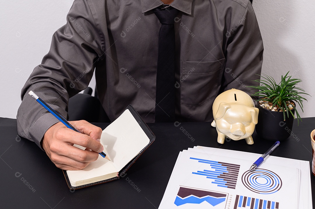 Empresário sentado em uma mesa tomando notas