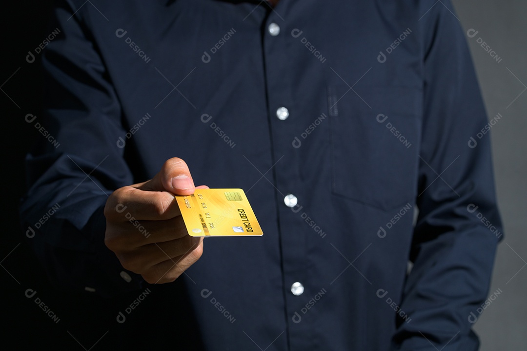 Um homem de negócios usando um cartão de crédito amarelo