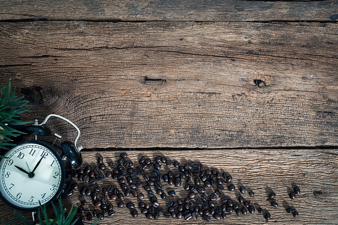 Um relógio e grãos de café na vista superior da mesa