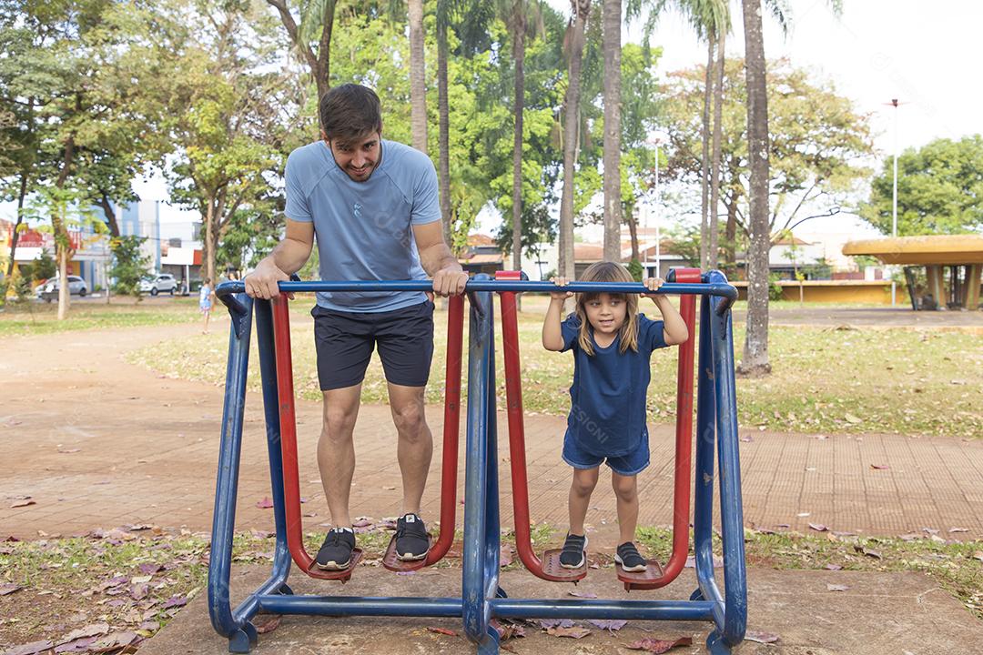pai e filha fazendo exercício em aparelhos ao ar livre