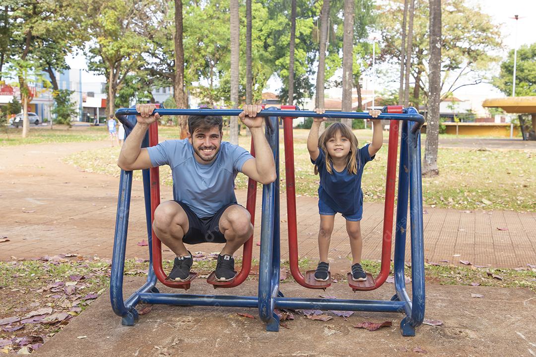 pai e filha fazendo exercício em aparelhos ao ar livre