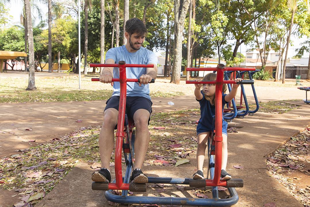 pai e filha fazendo exercício em aparelhos ao ar livre