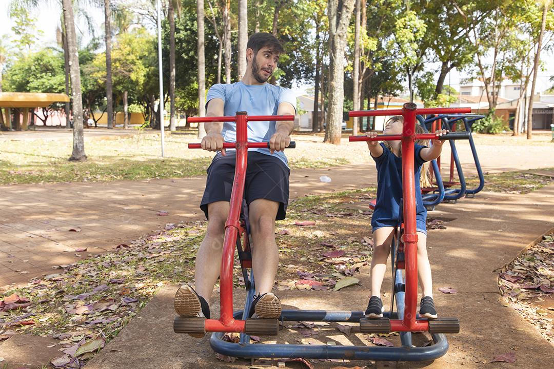 pai e filha fazendo exercício em aparelhos ao ar livre