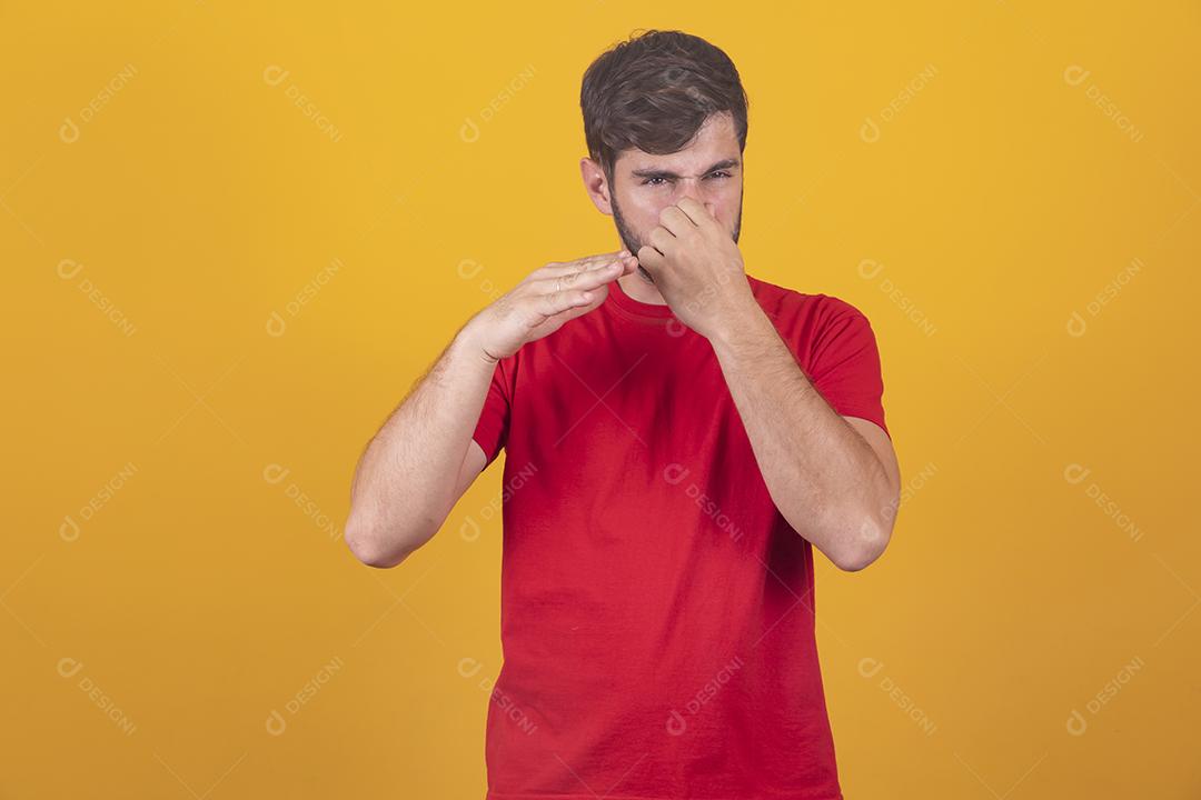 jovem cobrindo o nariz com intolerância ao odor, mau cheiro,