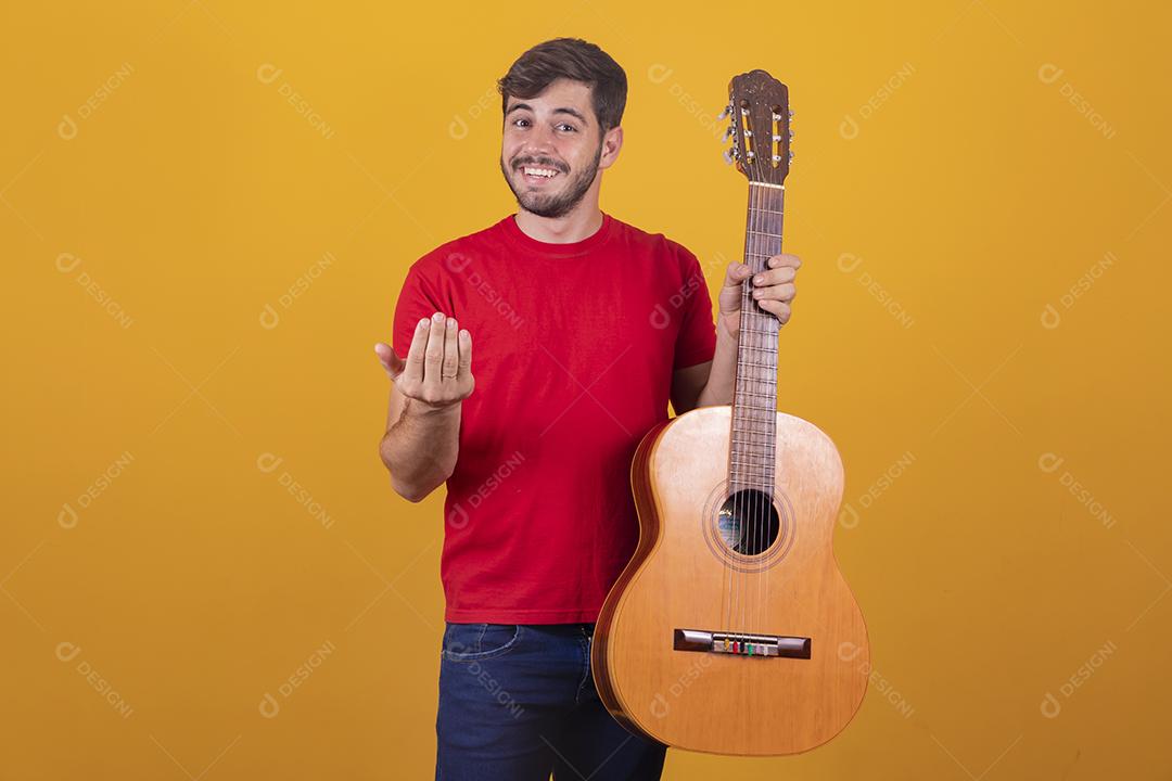 jovem tocando guitarra em fundo amarelo com espaço livre para texto.