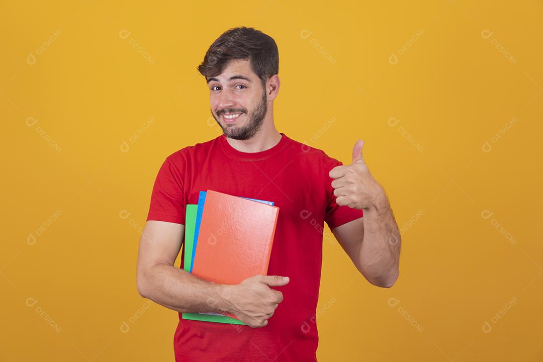 Menino jovem estudante em fundo amarelo com o polegar para cima. garanhão feliz